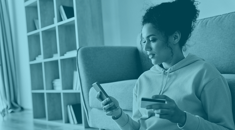 Content woman holding cell phone while sitting on floor in living room. Related to issuer declines of credit card purchases
