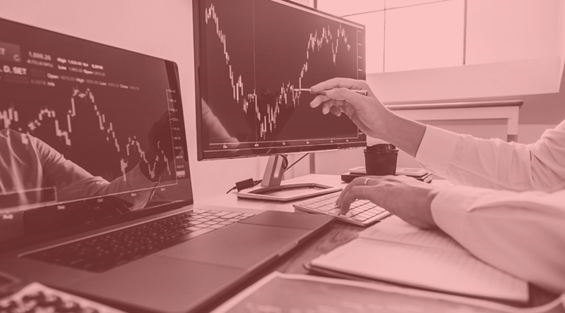 Hand points to stock market charts on computer screen to show concept of increased sales with the right CBD merchant payment processor